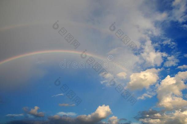 有彩虹的云。 五颜六色的弯曲条在天空中，由于阳光在雨滴中折射。