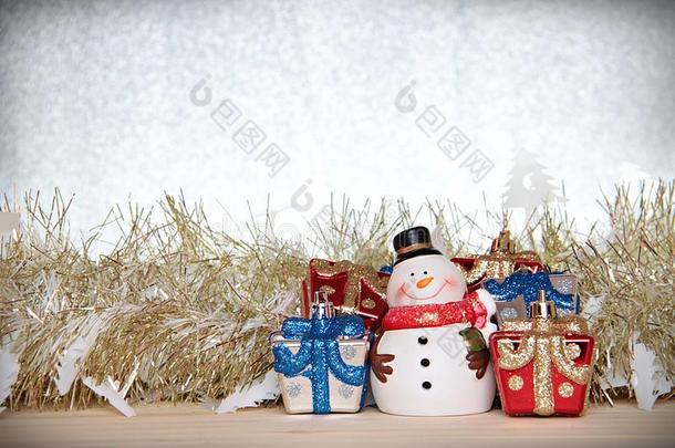 可爱的雪人，圣诞礼物盒或礼物，金色的流光或金属在木头上，<strong>银色</strong>的<strong>闪光背景</strong>