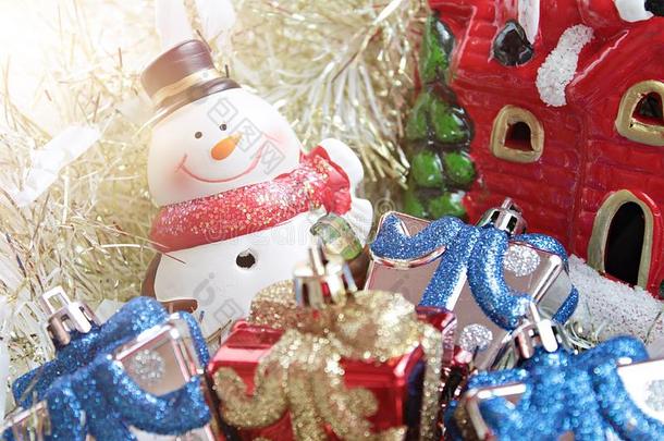 可爱的雪人，圣诞礼物盒或礼物和圣诞老人的房子在金色流光或金属背景