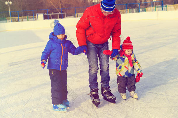 父亲和两个孩子在冬天滑冰