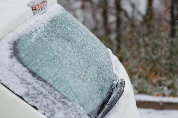 汽车覆盖着白色的第一场雪。 红色尾灯，反向灯和冰