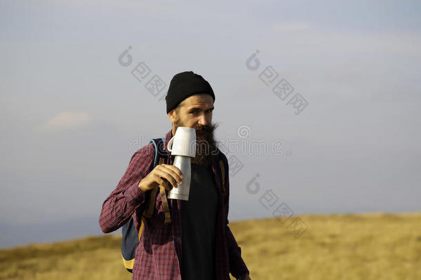 长胡子的男人带着热水瓶