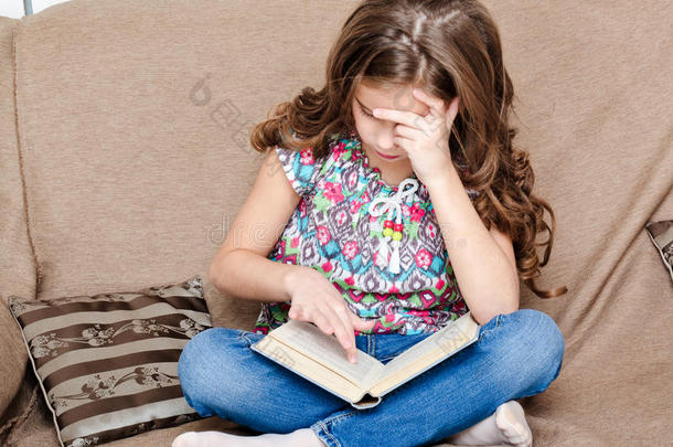 可爱的小女孩正在沙发上看书