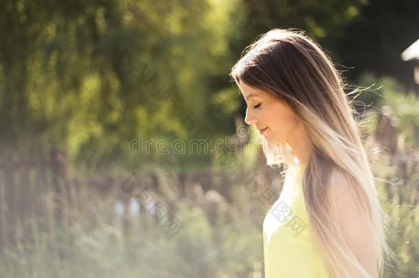美丽的年轻女人，留着长长的金发。 阳光明媚的夏天。