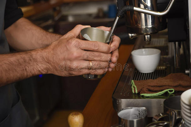 咖啡师关闭<strong>双</strong>手，在咖啡<strong>店</strong>准备美味的咖啡奶油操作机