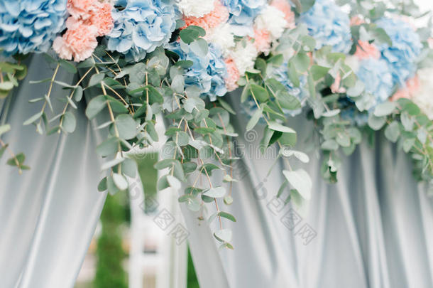 由淡粉色和蓝色绣球花制成的节日挂在婚礼祭坛上