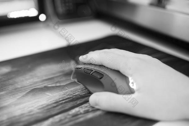 黑白电脑鼠标与人的手在鼠标垫Bokeh背景