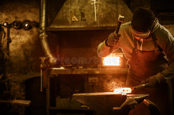 铁匠在铁砧上锻造熔化的金属