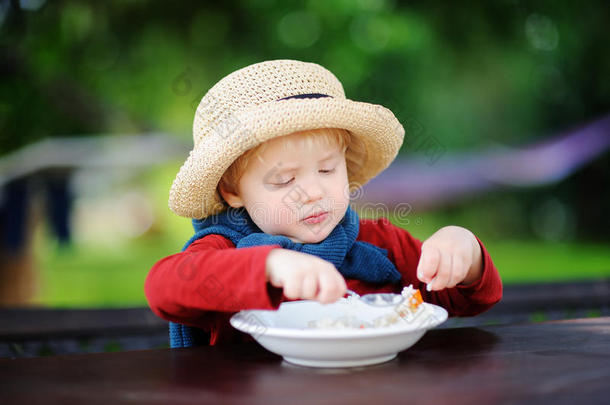 可爱的蹒跚学步的男孩在户外<strong>吃米饭</strong>麦片