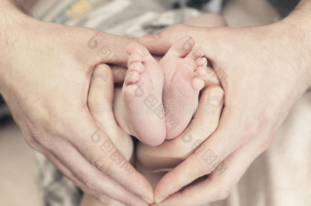 孩子们的脚放在父母心形的手上。母亲，父亲和孩子。幸福家庭理念。美丽的概念
