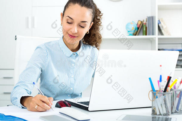 商务女士<strong>坐在</strong>办公桌<strong>前</strong>拿着笔记本<strong>电脑</strong>