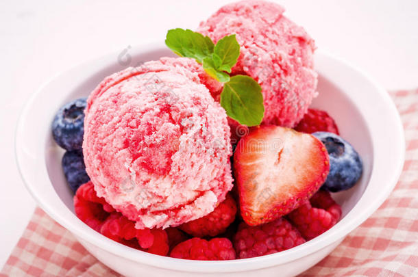 关闭冰淇淋混合浆果<strong>水果</strong>，覆盆子，蓝莓，<strong>草莓</strong>和薄荷叶设置在<strong>白</strong>色碗<strong>白</strong>色木制