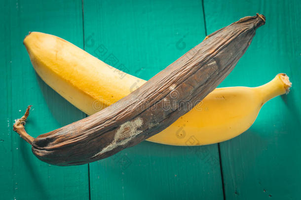 木制背景上新鲜腐烂的香蕉