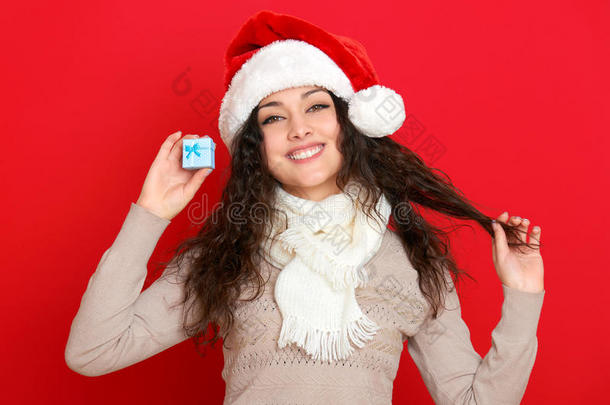 女孩在圣诞帽肖像与<strong>小礼品</strong>盒摆在红色背景，圣诞节假日概念，快乐和情感