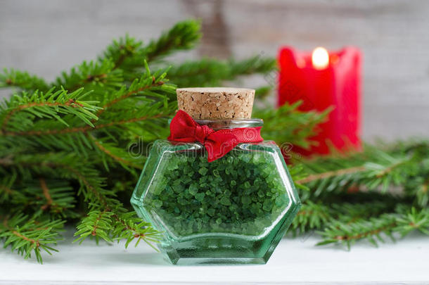 一瓶绿色浴盐和冷杉树枝。 圣诞保健礼物。 水疗概念。