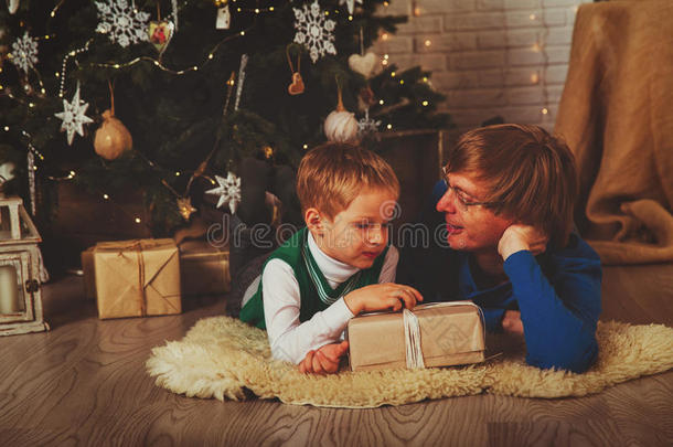 圣诞愿望-父亲和儿子在装饰好的客厅里拿礼物