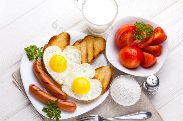 情人节`早餐-心形煎蛋和香肠。 上面的风景