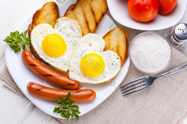 情人节`早餐-心形煎蛋和香肠。 上面的风景