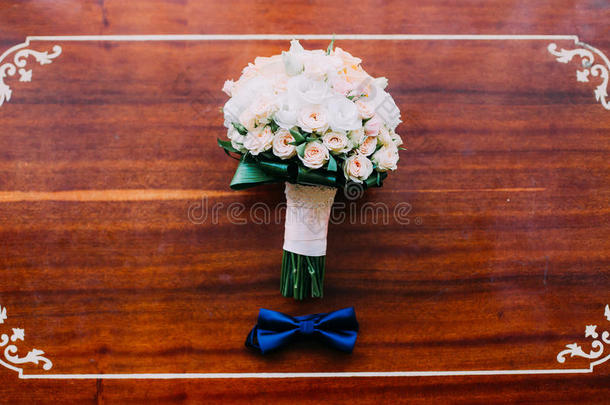 领结和<strong>婚礼</strong>花束玫瑰在乡村木桌上。 <strong>婚礼</strong>的概念。 <strong>复古</strong>过滤器。