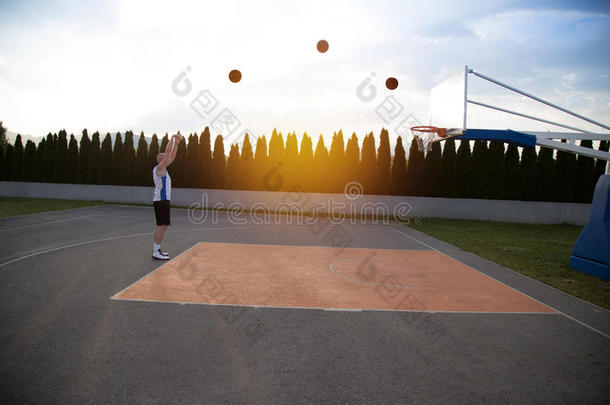 一个人，站得很高，准备在公园里打篮球