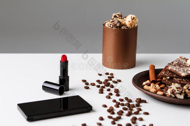 白色背景上的装饰化妆品、咖啡豆和巧克力。