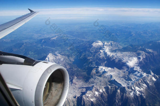 奥地利-2016年10月：从飞机上看到的阿尔卑斯山，带有飞机涡轮或发动机的机翼视图