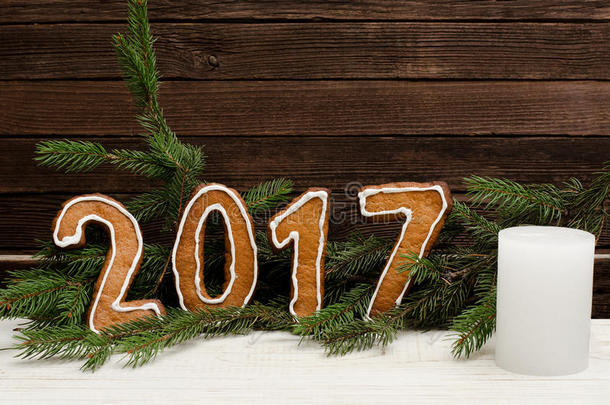图中<strong>2017</strong>年的姜饼背景为云杉树枝和木<strong>墙</strong>，白色蜡烛