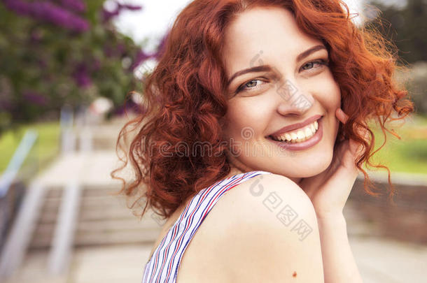 美丽的红头发女人，清新无瑕的皮肤和卷曲的头发