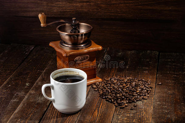 在深色木材背景下的杯子咖啡和咖啡机