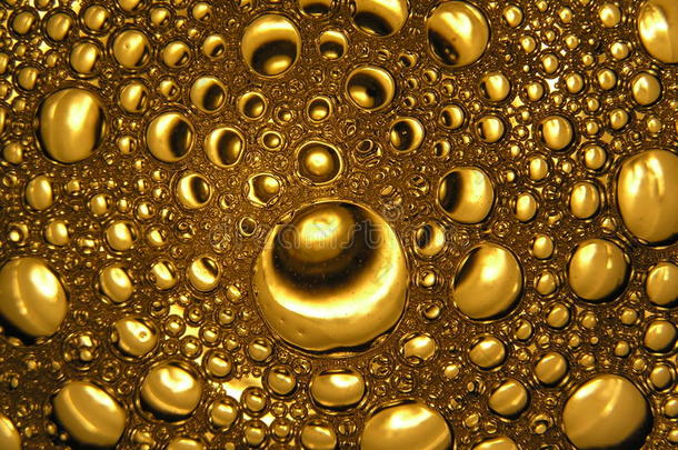金色的气泡在啤酒抽象的光关闭，水滴