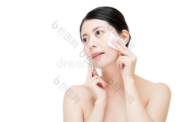 美丽的亚洲女人用棉签从脸上<strong>卸妆</strong>