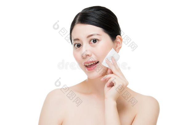 美丽的亚洲女人用棉签从脸上<strong>卸妆</strong>