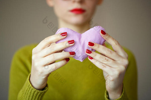 紧紧抓住女人手中的粉红色心脏。 情人节的形象