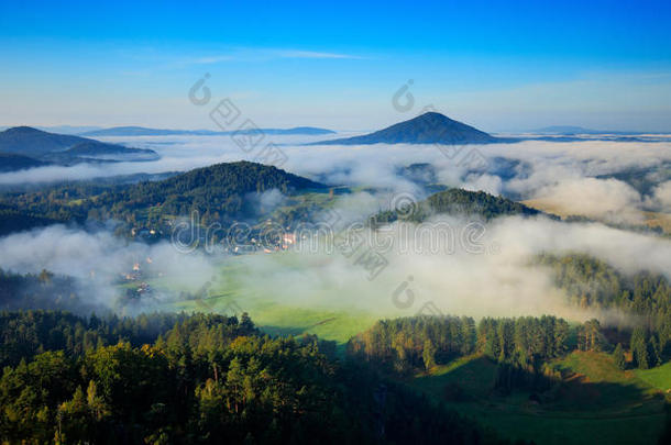 捷克典型的夏季景观有雾。 有雾的早晨的山丘和村庄。 波西米亚瑞士公园的早秋山谷。