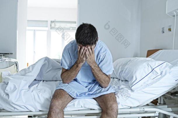 绝望的人独自坐在病床上，在诊所里悲伤和绝望地生病