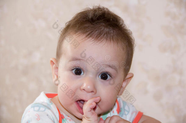 男孩哭着咬着你的手指，爬上第一颗牙齿。 生一个7个月大的孩子