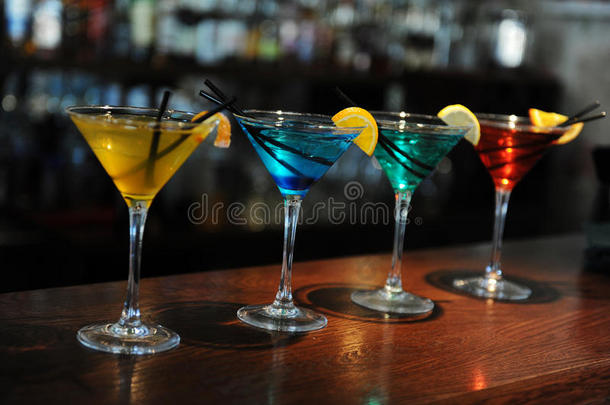 酒吧里有四种颜色的鸡尾酒。 黄色，蓝色，绿色，红色。 用柠檬片装饰