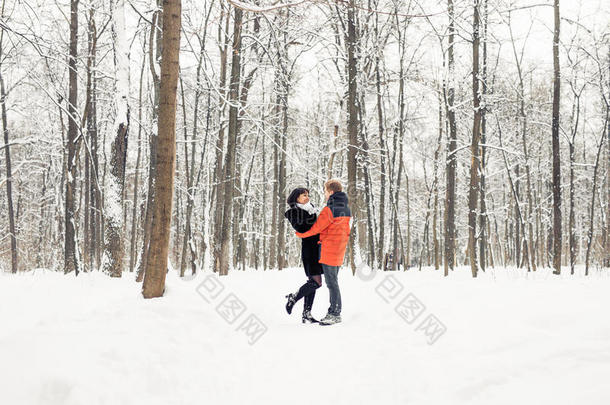 一对相爱的夫妇在冬天的公园散步。 下雪，冬天。
