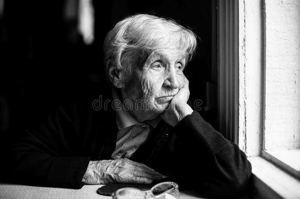 老妇人悲伤地望着窗外