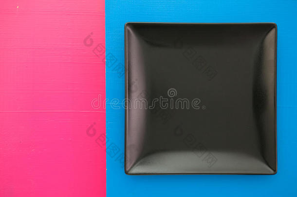 蓝色和粉红色背景上的空黑色<strong>陶瓷盘子</strong>，方形<strong>盘子</strong>