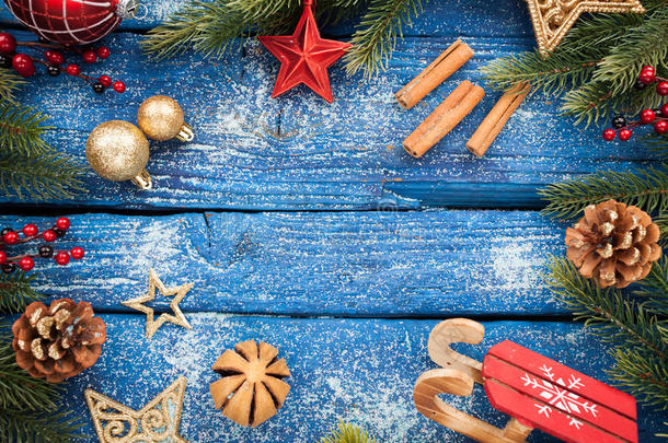 在蓝色木质背景上有球、星星和装饰的圣诞边框。摄影棚镜头