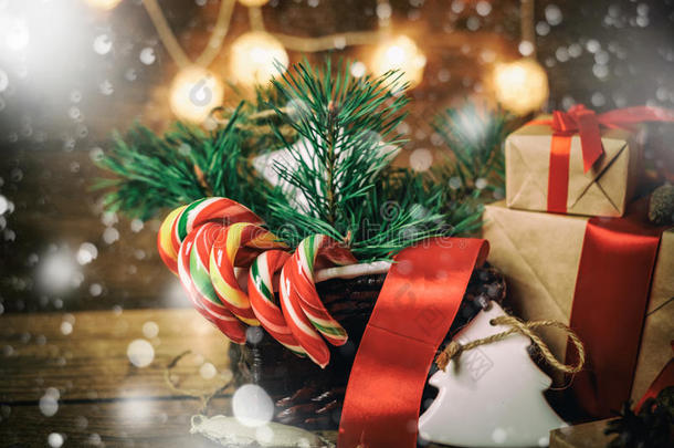 圣诞礼物与盒子，针叶树，篮子，糖果甘蔗锥在木制背景。 老式风格与拉雪
