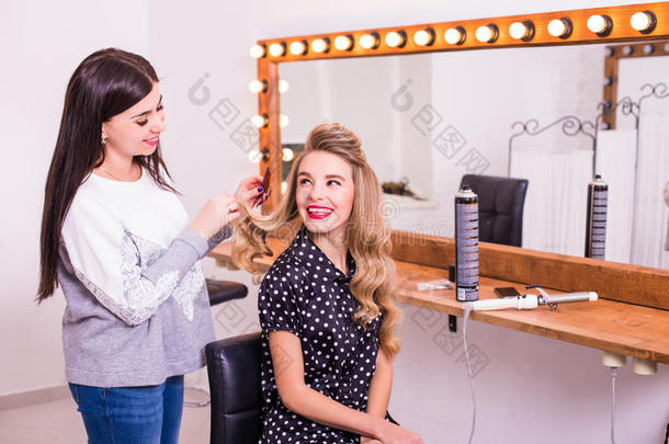 女理发师站着给可爱的年轻女人做发型
