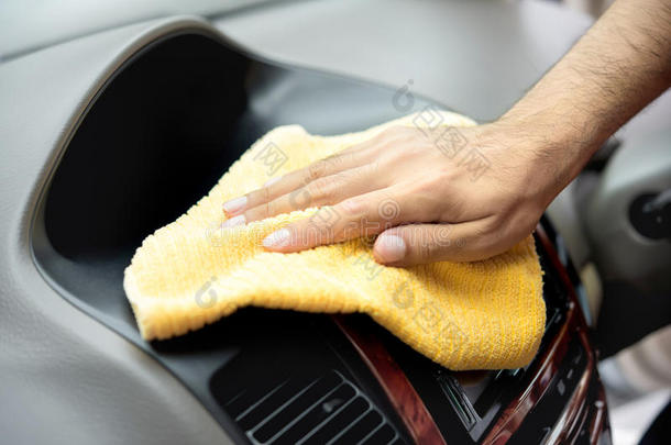 一个人用微纤维布手工清洁汽车内部