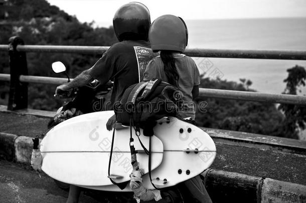 <strong>父亲和女儿</strong>骑摩托车<strong>和</strong>冲浪板去<strong>海滩</strong>。 黑白照片。
