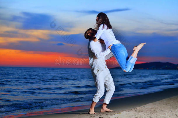 一对夫妇在海滩上散步，拥抱爱情夫妇