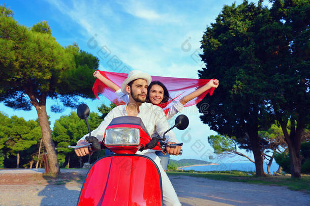 美丽的年轻夫妇相爱，享受和享受乐趣骑滑板车