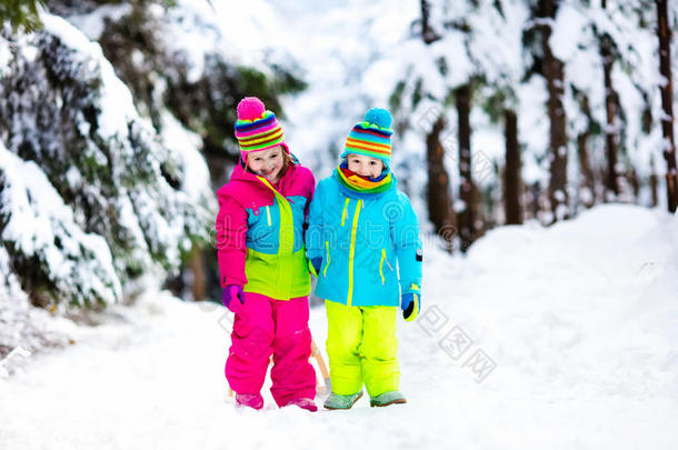 冬天公园里的孩子们在雪橇上玩雪