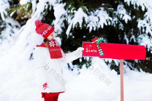 孩子在雪中的圣诞信箱给圣诞老人写信