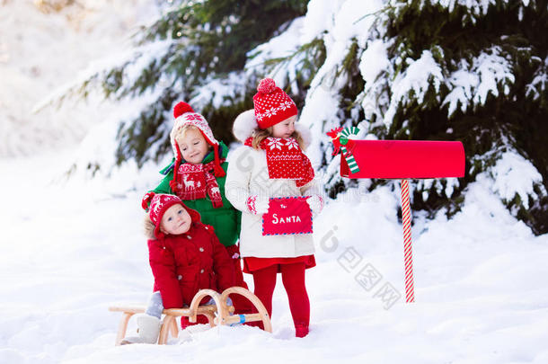 孩子们在雪中的圣诞邮箱给圣诞老人写信